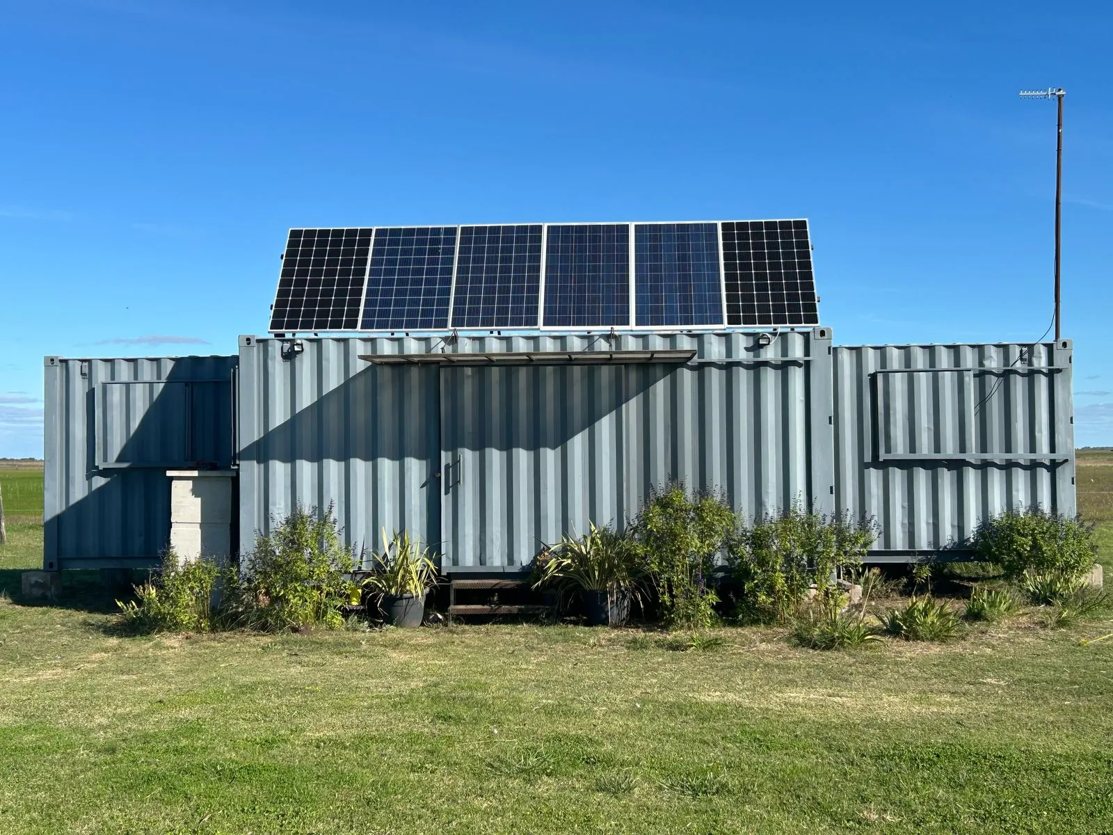 POLO Fragata: dos containers de 40 pies apareados, exterior terminado con cielo despejado y paneles solares en el techo.